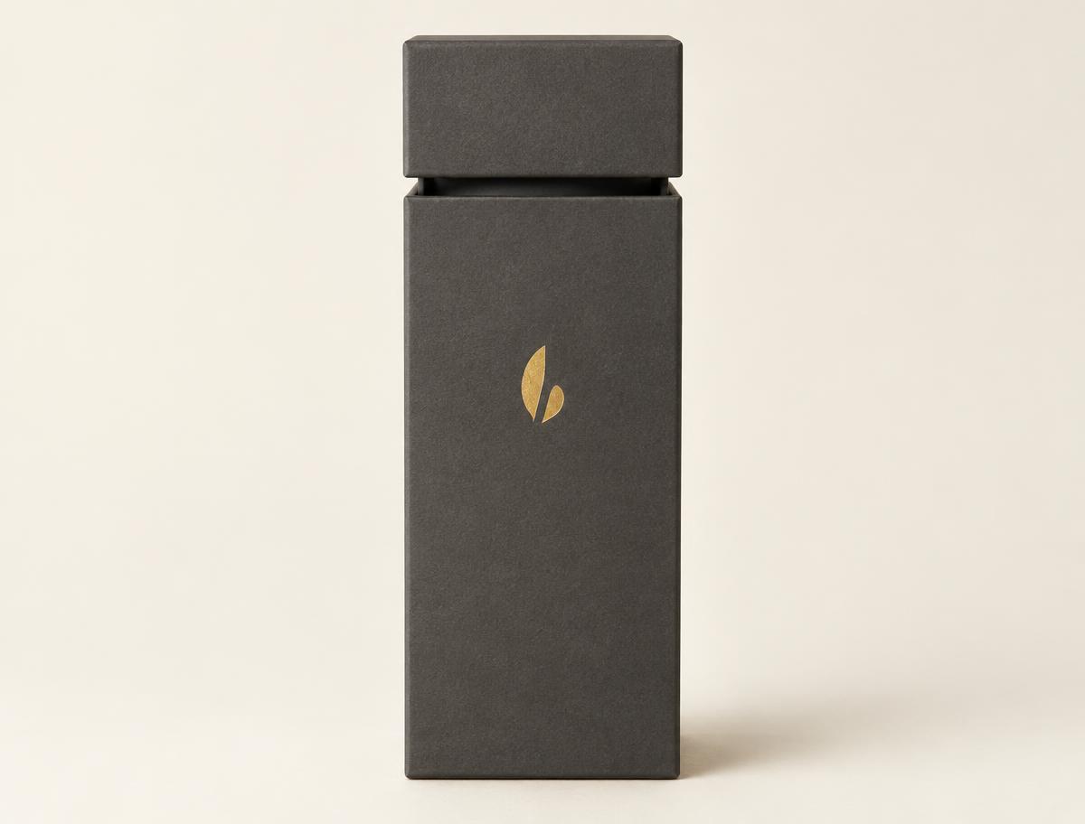 Tall vertical rigid two-piece bottle box in charcoal wrap with a gold foil stamp